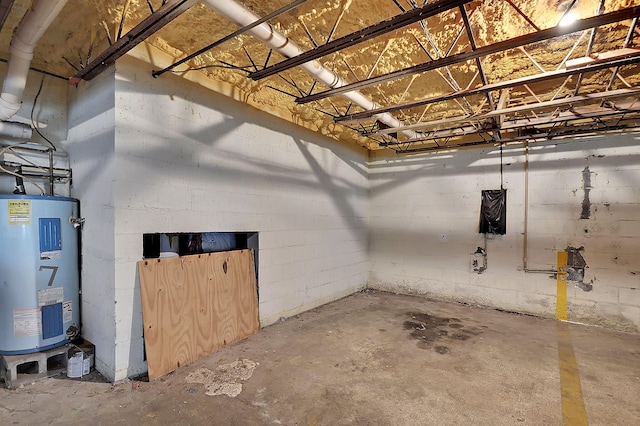 basement featuring concrete block wall and water heater