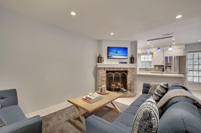 living room with baseboards, a fireplace, visible vents, and recessed lighting