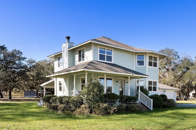 view of front of house featuring a porch, a front yard, and a garage