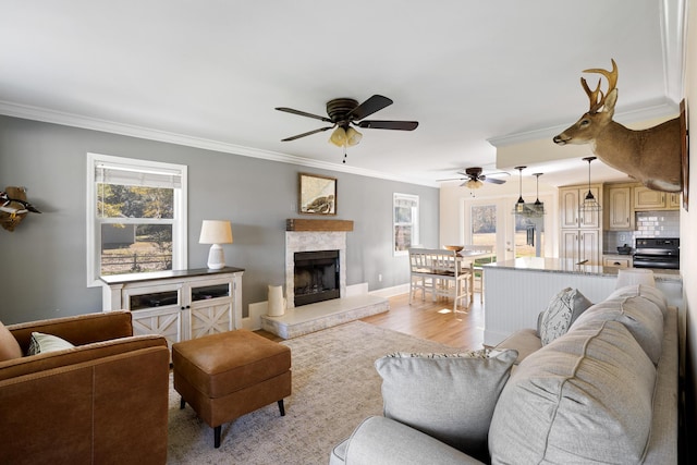 living room featuring crown molding, light hardwood / wood-style flooring, and ceiling fan