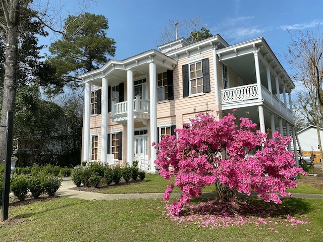 neoclassical / greek revival house with a balcony and a front yard