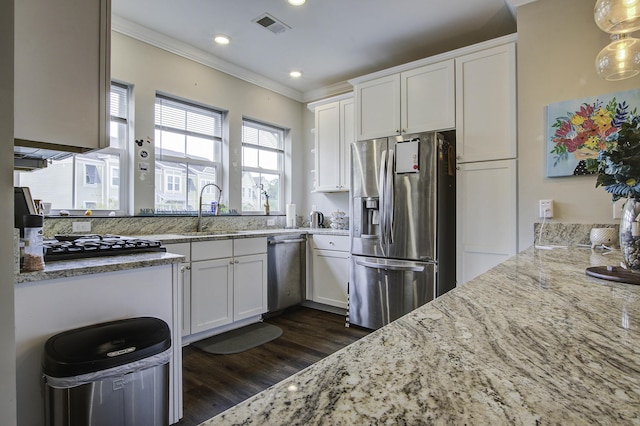 kitchen with stainless steel appliances, a sink, visible vents, white cabinetry, and light stone counters