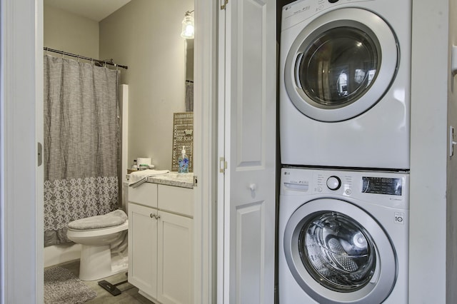washroom featuring stacked washer and dryer and laundry area