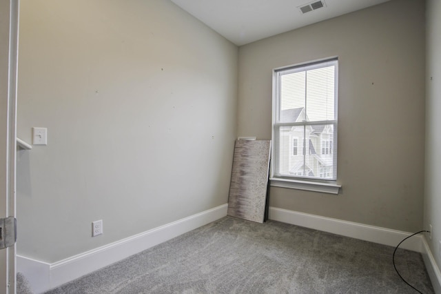 carpeted empty room with baseboards, visible vents, and a wealth of natural light