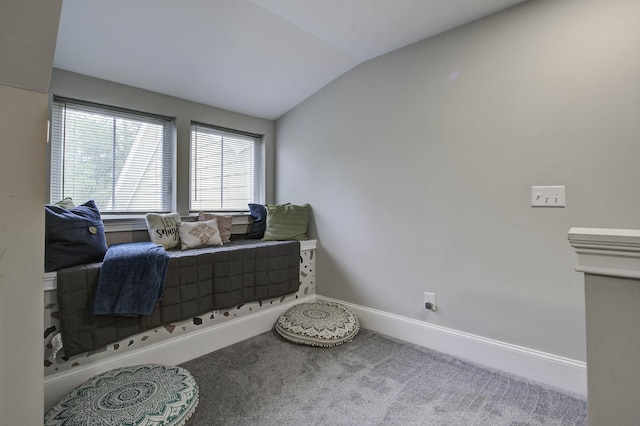 living area with vaulted ceiling, baseboards, and carpet