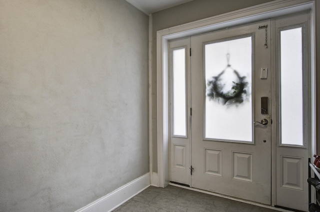 doorway with tile patterned flooring and baseboards