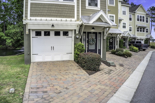 townhome / multi-family property with an attached garage and decorative driveway