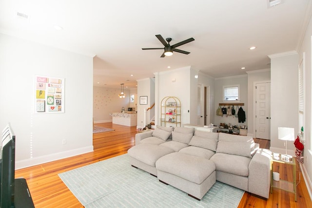 living room with hardwood / wood-style flooring, ornamental molding, and ceiling fan