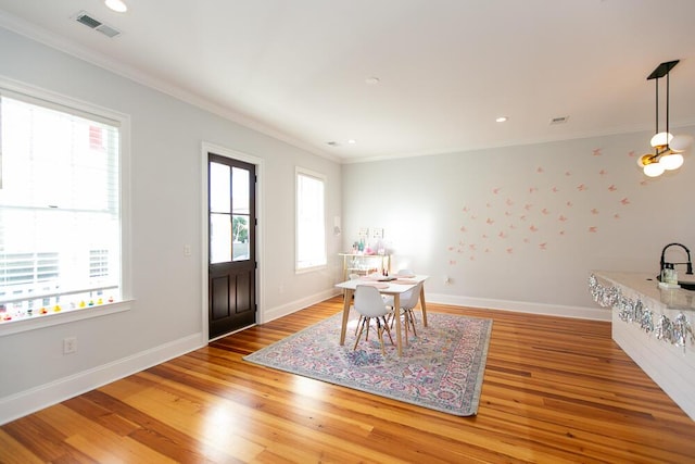 dining room with ornamental molding, a chandelier, and hardwood / wood-style floors