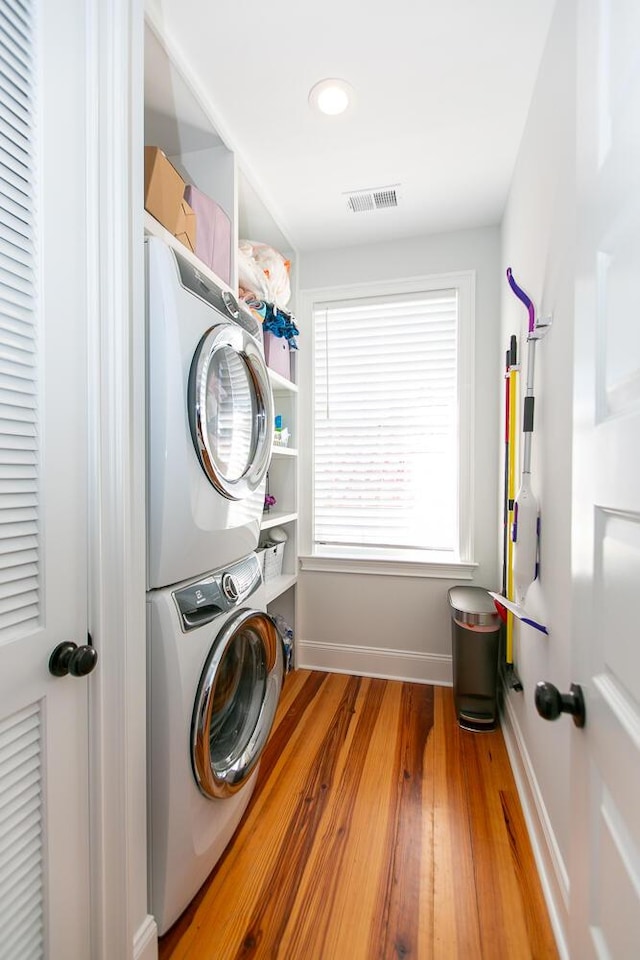 washroom featuring stacked washer and clothes dryer and hardwood / wood-style floors