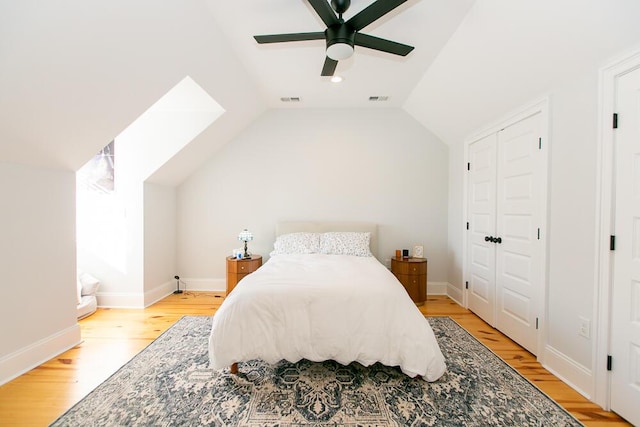 bedroom featuring ceiling fan, vaulted ceiling, a closet, and light wood-type flooring