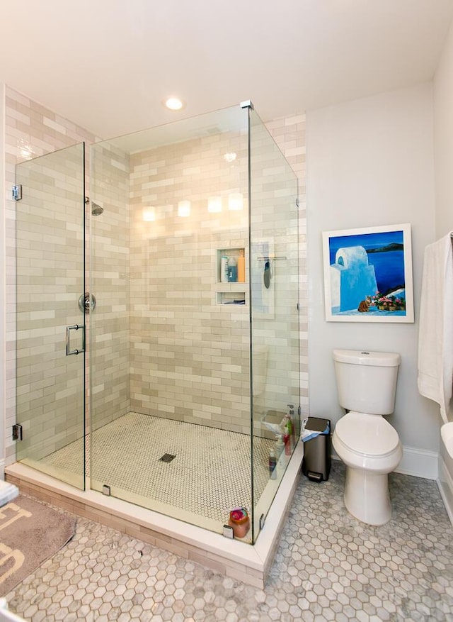 bathroom with tile patterned flooring, a shower with door, and toilet