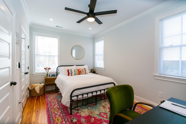 bedroom with crown molding, ceiling fan, and hardwood / wood-style flooring