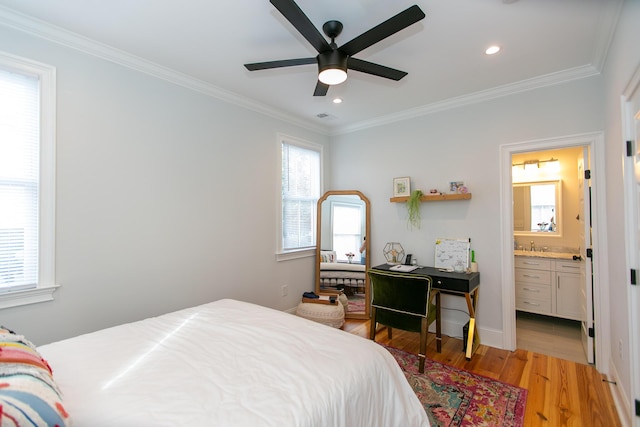 bedroom with crown molding, ceiling fan, ensuite bath, and light hardwood / wood-style flooring