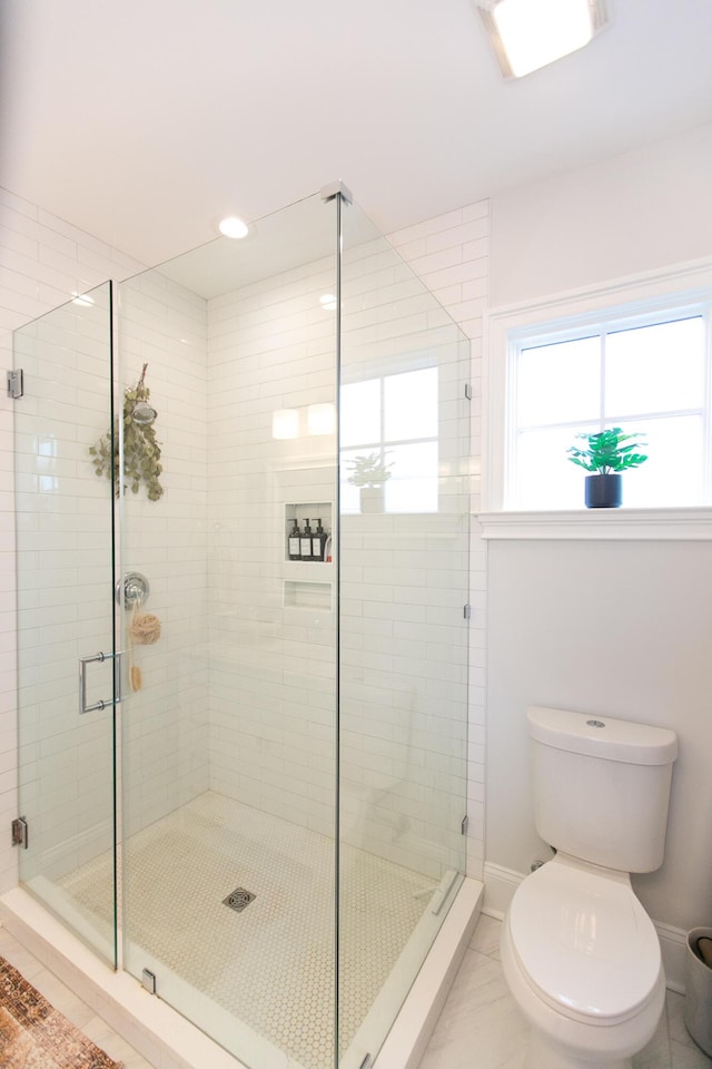 bathroom featuring toilet and an enclosed shower