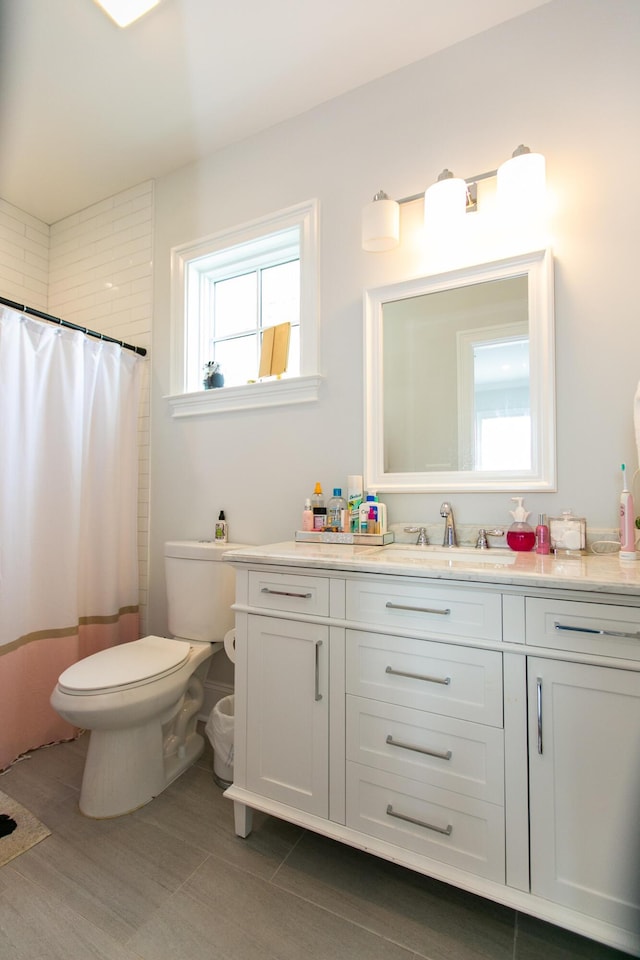 bathroom featuring vanity, curtained shower, and toilet