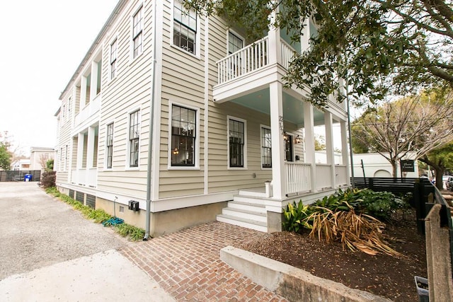 view of home's exterior featuring a porch and a balcony