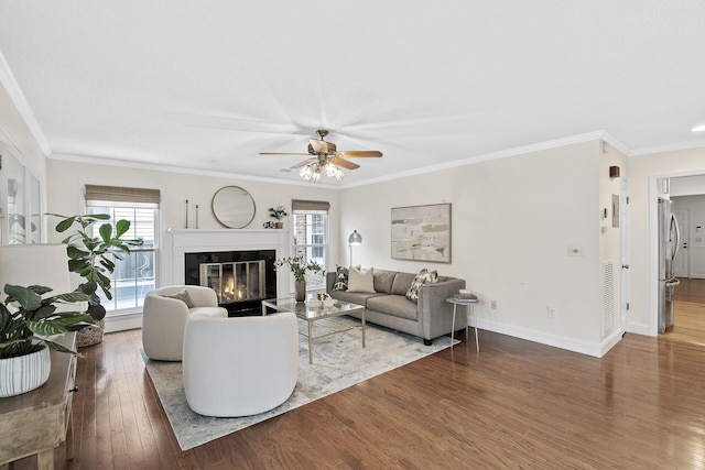 living room featuring ceiling fan, ornamental molding, and hardwood / wood-style flooring