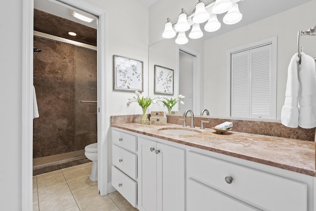 bathroom with toilet, a tile shower, vanity, and tile patterned floors