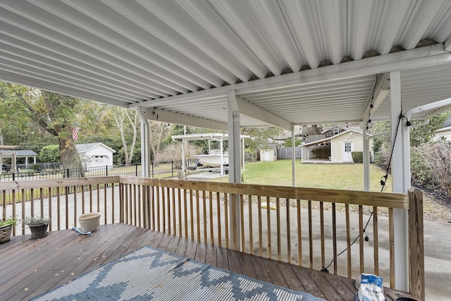 wooden terrace featuring a lawn and a storage unit