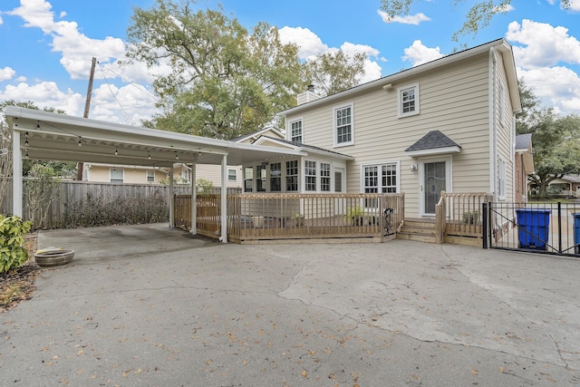 rear view of house with a carport and a wooden deck