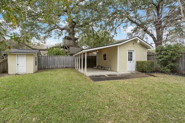 back of house with a lawn, a patio area, and a storage shed