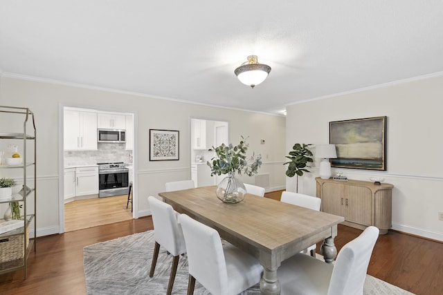 dining space featuring dark hardwood / wood-style flooring and ornamental molding