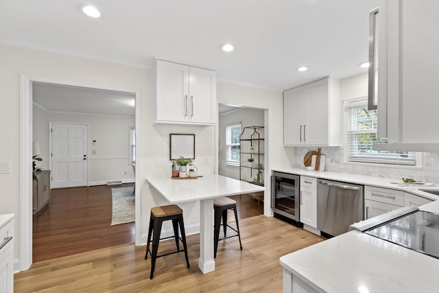 kitchen featuring wine cooler, white cabinetry, stainless steel dishwasher, and light wood-type flooring