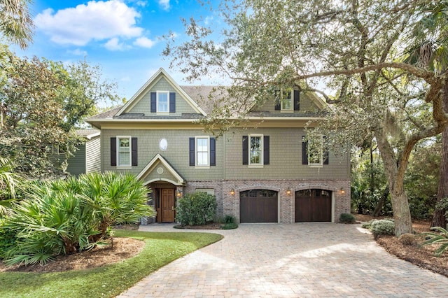 view of front of house featuring a garage, decorative driveway, and brick siding