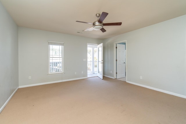 carpeted spare room with ceiling fan