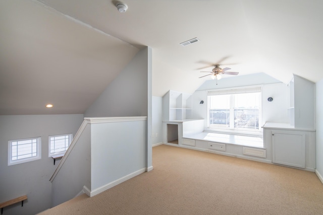 bonus room with light carpet, lofted ceiling, and ceiling fan