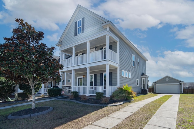 view of front facade with a porch, central AC, a garage, an outbuilding, and a balcony