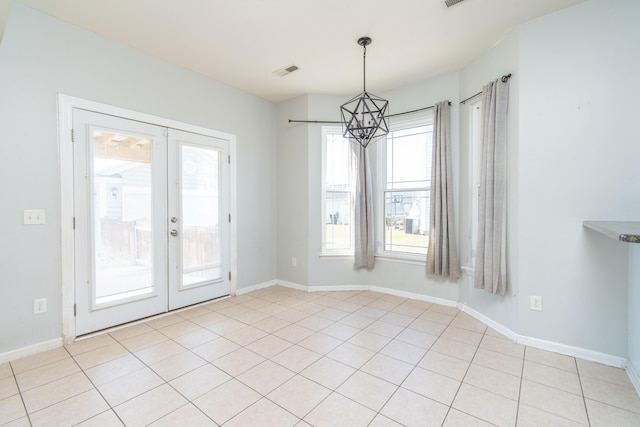 unfurnished dining area featuring french doors and a notable chandelier