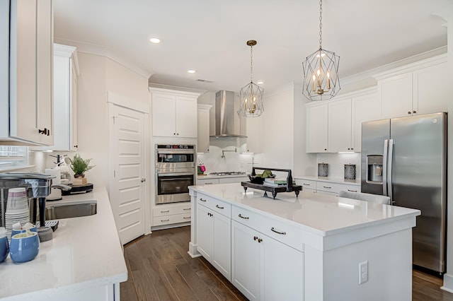 kitchen featuring white cabinets, wall chimney exhaust hood, a kitchen island, and stainless steel appliances