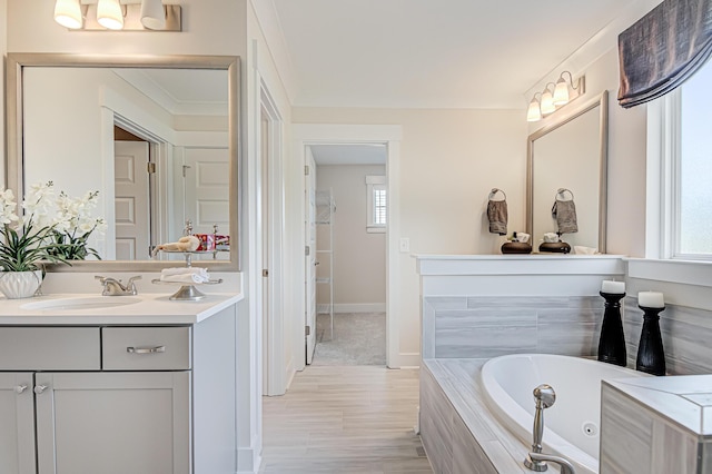 full bath featuring baseboards, vanity, and a tub with jets