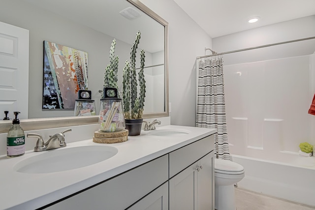 full bath with visible vents, a sink, toilet, and double vanity