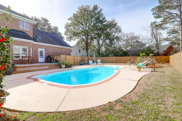 view of swimming pool featuring a patio area, a fenced backyard, a wooden deck, and a fenced in pool