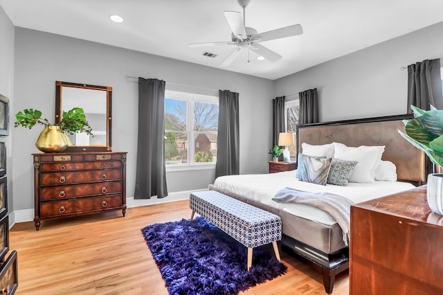 bedroom with light wood-type flooring, ceiling fan, baseboards, and recessed lighting