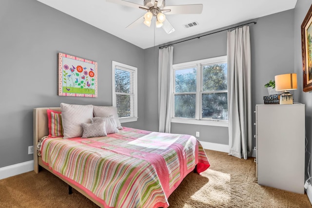 carpeted bedroom with a ceiling fan, visible vents, and baseboards