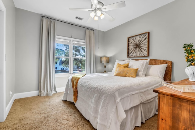 carpeted bedroom featuring ceiling fan, visible vents, and baseboards