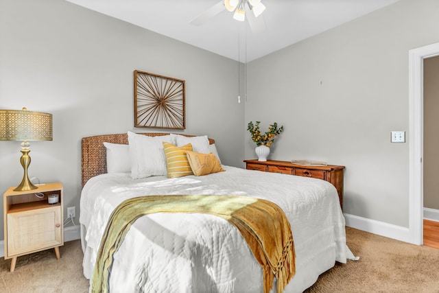 bedroom with light carpet, a ceiling fan, and baseboards