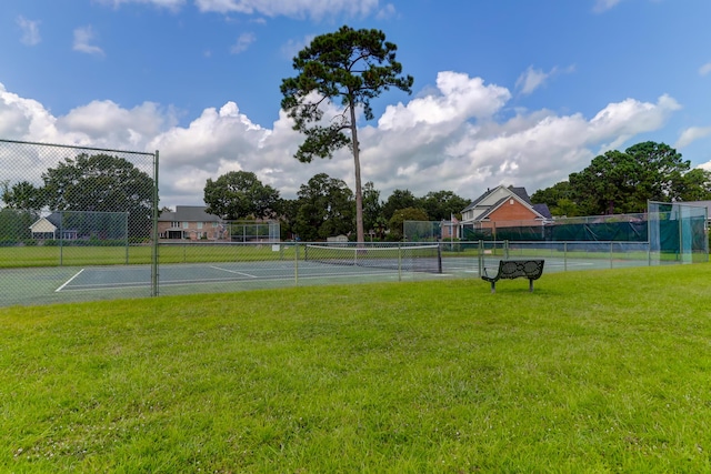 view of sport court featuring a lawn and fence