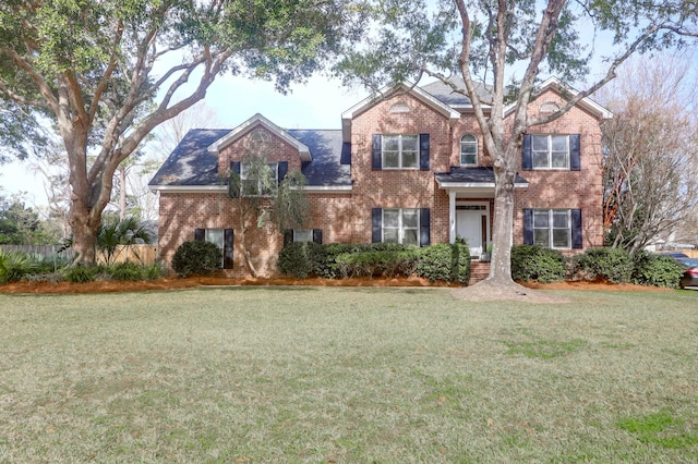 view of front facade with brick siding and a front yard