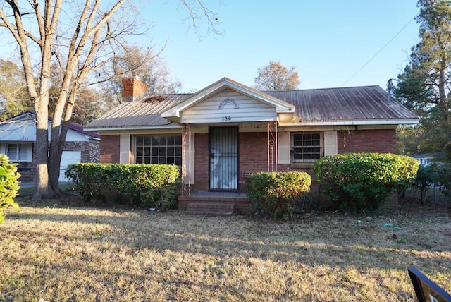 150 M L King Blvd, Saint Stephen, SC 29479 - view of front facade featuring a chimney, metal roof, and brick siding
