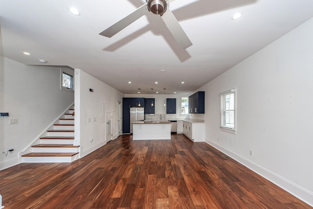 unfurnished living room with ceiling fan and dark hardwood / wood-style flooring