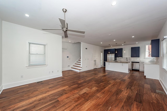 unfurnished living room featuring ceiling fan and dark hardwood / wood-style flooring