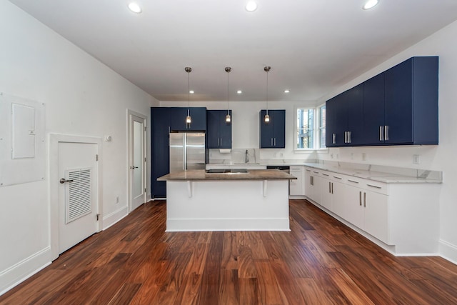 kitchen with stainless steel fridge, blue cabinetry, a center island, dark hardwood / wood-style floors, and hanging light fixtures