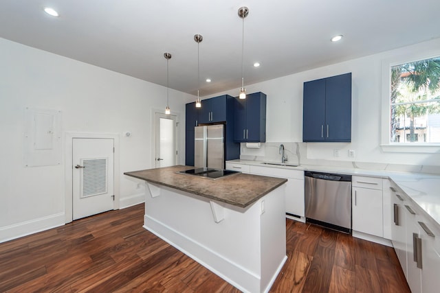 kitchen with blue cabinetry, a center island, decorative light fixtures, white cabinets, and appliances with stainless steel finishes