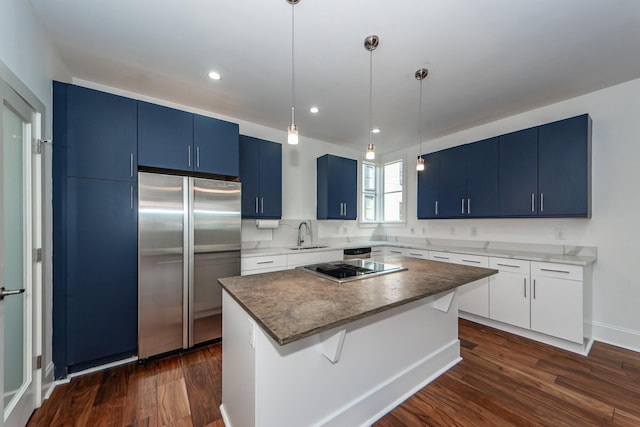 kitchen featuring white cabinetry, a kitchen island, stainless steel appliances, and dark hardwood / wood-style floors