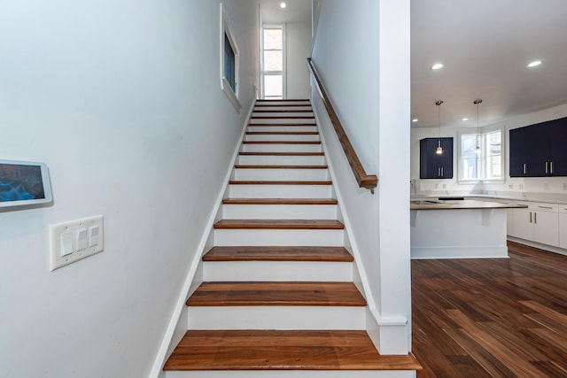 stairs with hardwood / wood-style flooring and a healthy amount of sunlight